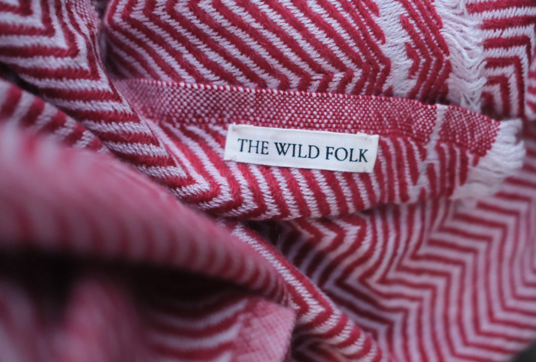 Detailaufnahme des Wollschals aus Kaschmir mit dem Brandlabel und der ZickZack Musterung.