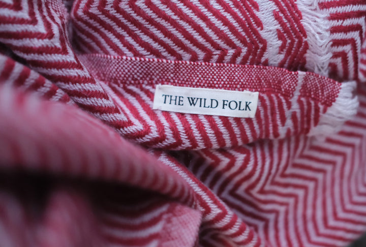 Detailaufnahme des Wollschals aus Kaschmir mit dem Brandlabel und der ZickZack Musterung.