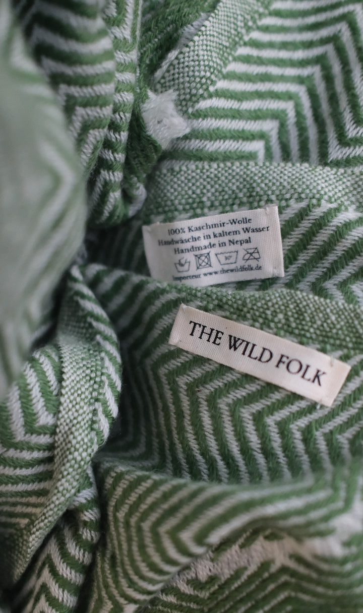 Detailaufnahme des Fischgrat Musters und des Brand-Labels und der Waschanleitung.