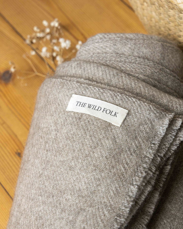 Brandlabel von heWildFolk auf einer warmen Decke aus Yakwolle.