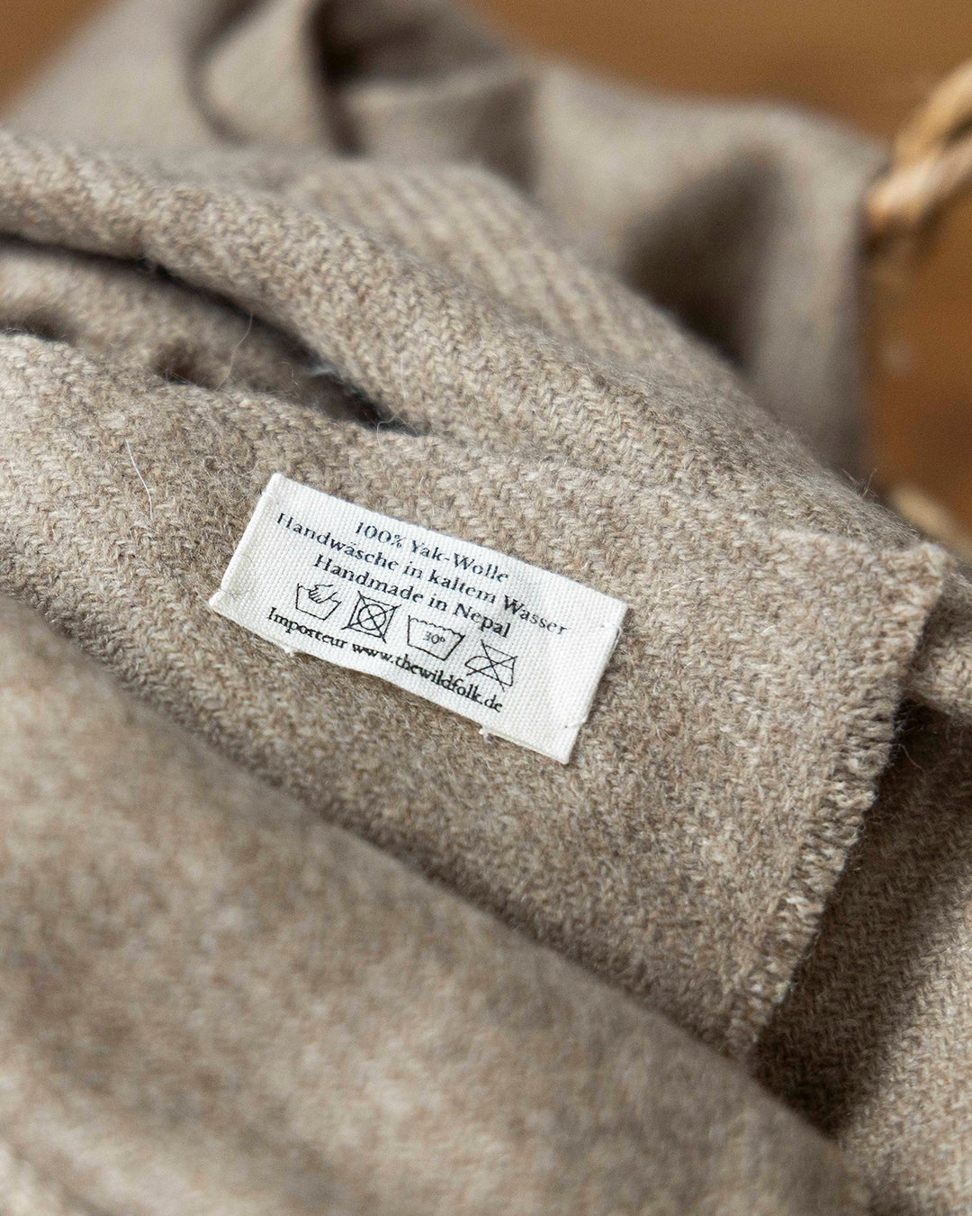 Detailaufnahme des Waschlabels an der großen Yakwolle-Decke.