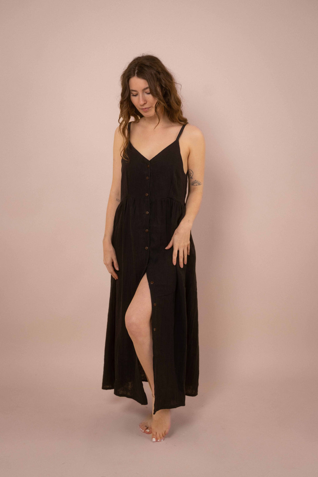 Ein elegantes schwarzes Maxikleid mit Knöpfen. das lange Trägerkleid hat einen V-Ausschnitt und ist minimalistisch gehalten. Vintage Musselinkleid. 