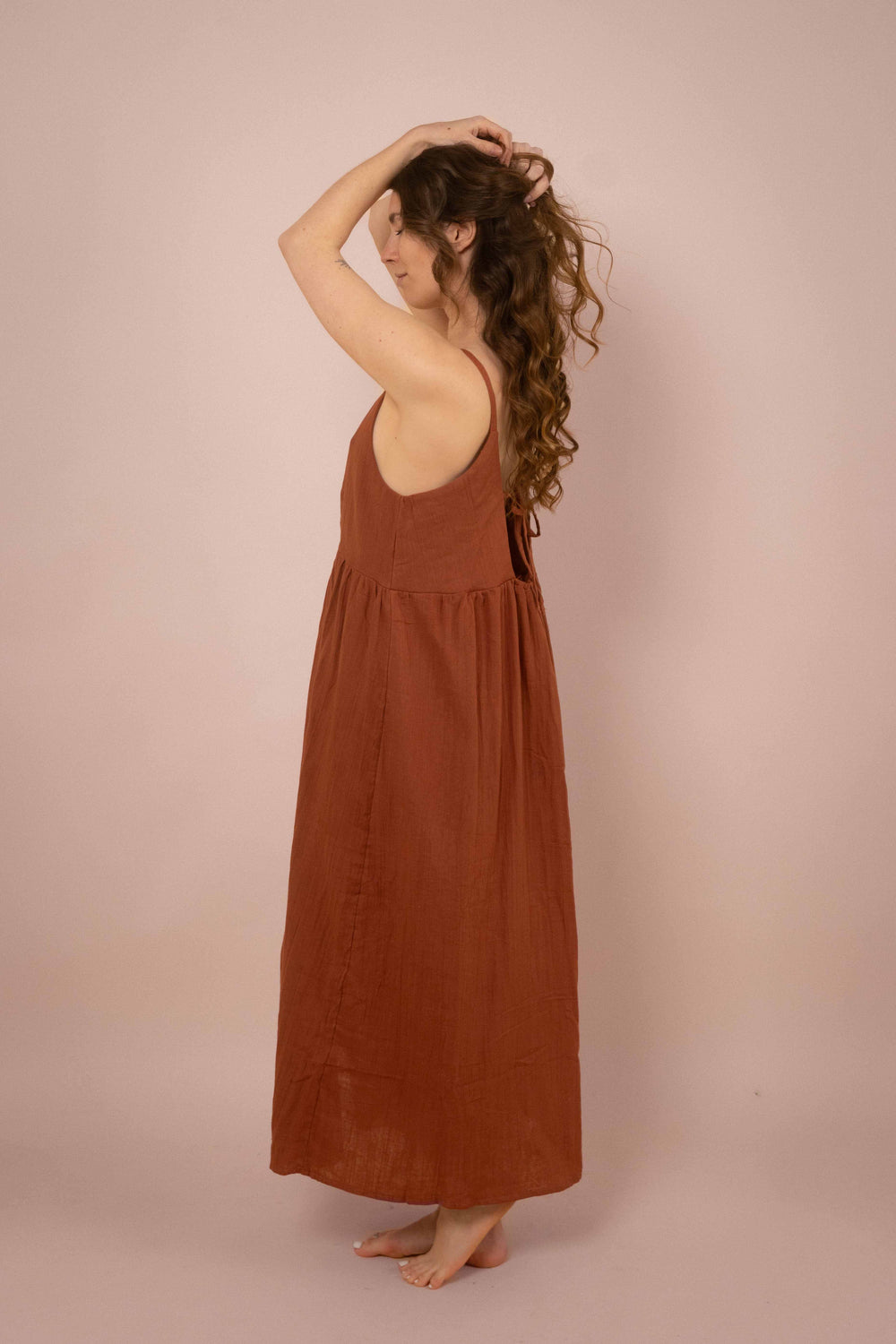 Ein langes rostrotes Vintage Kleid aus 100% Musselin Baumwolle. Das schlichte Boho Bauernkleid hat Knöpfen vorne und Träger.