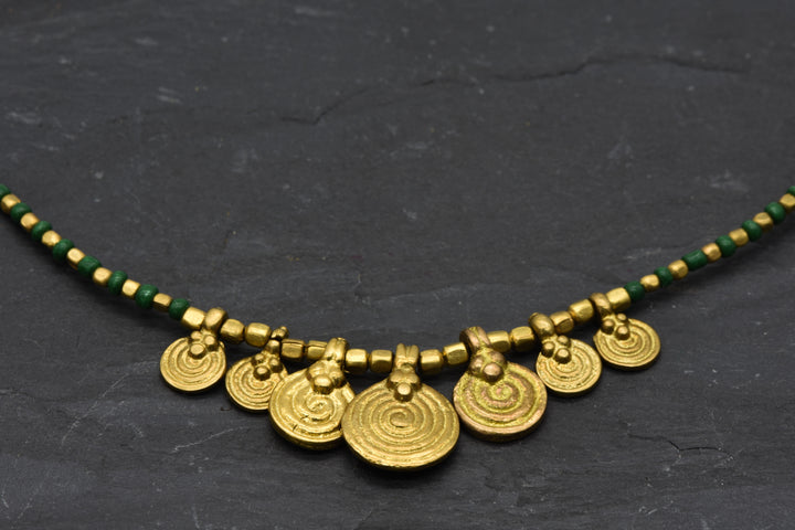 Spiral necklace with green pearls | Brass & glass