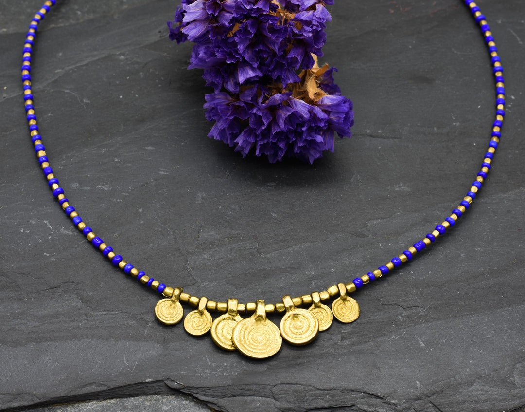 Spiral necklace with blue pearls | Brass & glass