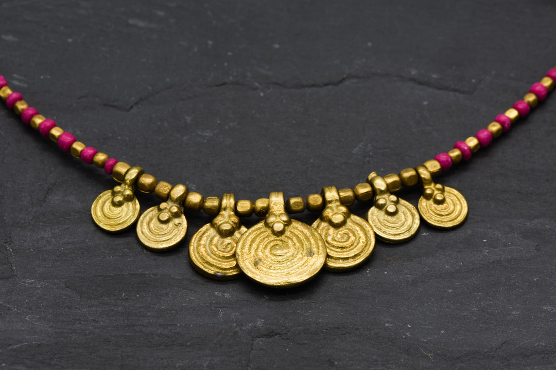 Spiral necklace with red pearls | Brass & glass